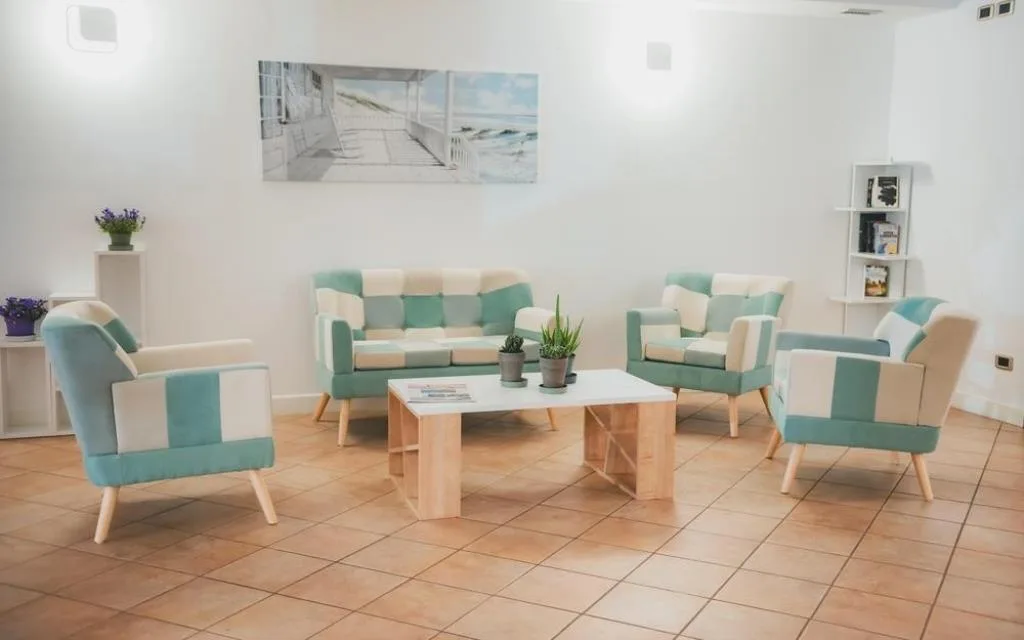 Zona lounge con poltrone e divani colorati e tavolino in legno