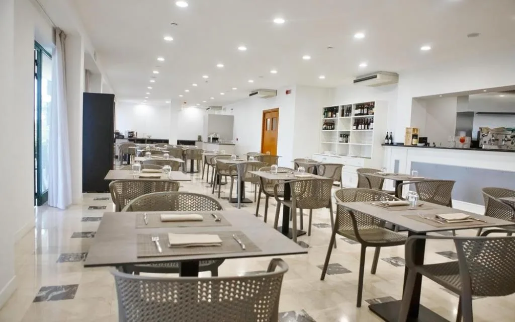 Sala interna del ristorante con tavoli apparecchiati e illuminazione moderna