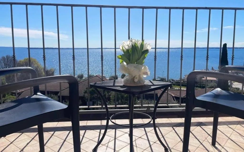 Balcone con tavolino, sedie e vista panoramica sul lago