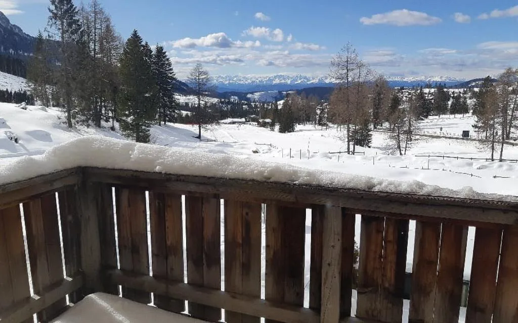 Vista invernale dal balcone dell'hotel con paesaggio innevato e montagne all'orizzonte
