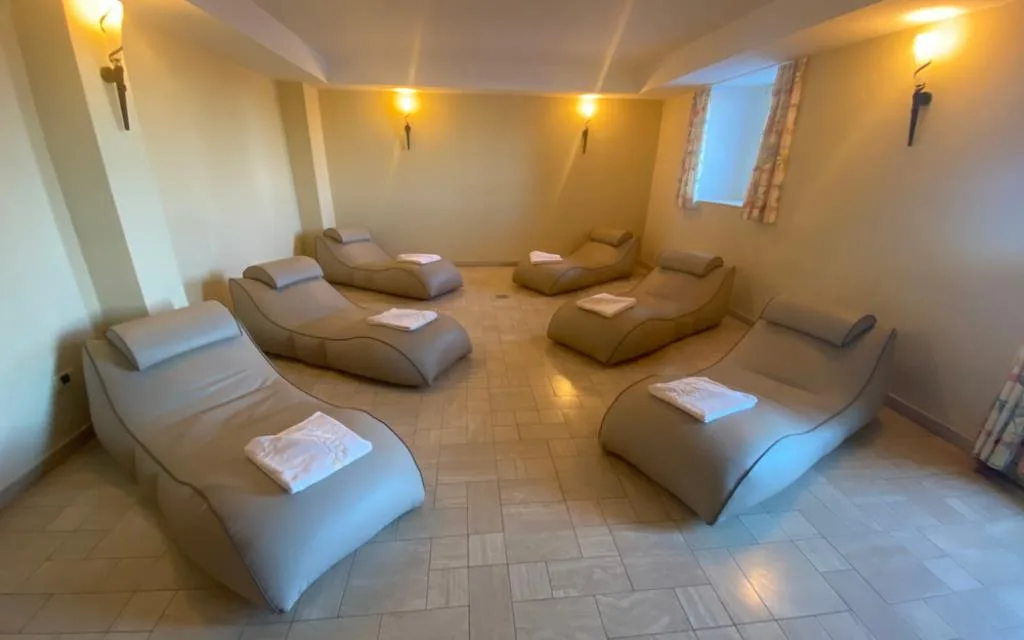 Area relax della spa con lettini imbottiti e asciugamani in ambiente soffuso