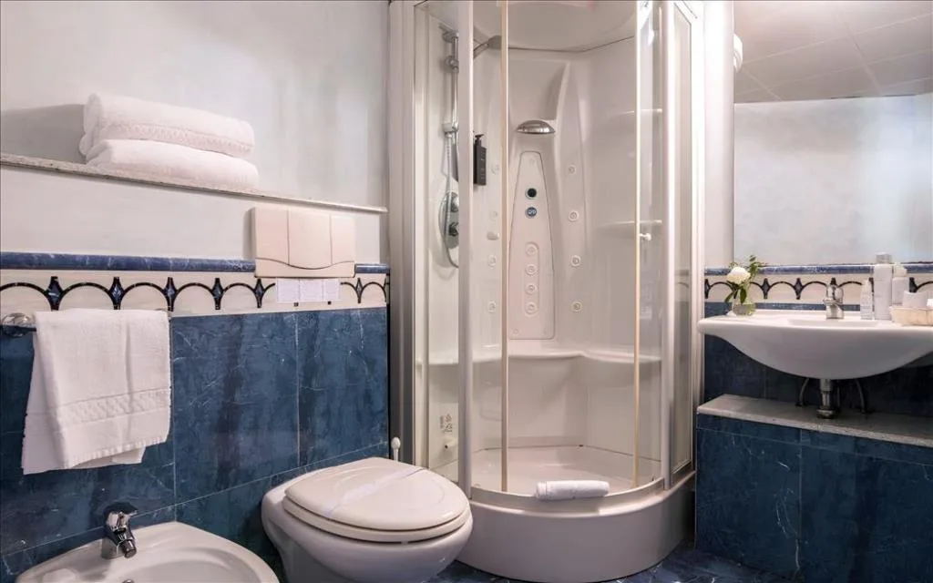 Bagno con doccia idromassaggio, WC, bidet e piastrelle blu