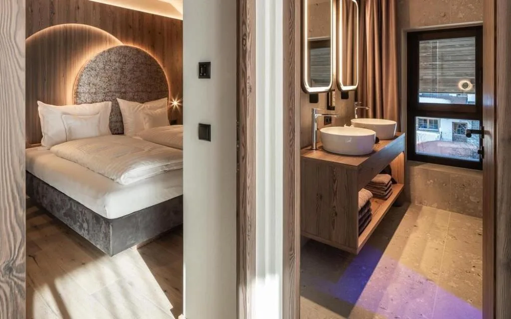 Vista tra camera da letto e bagno con doppio lavabo e luce naturale