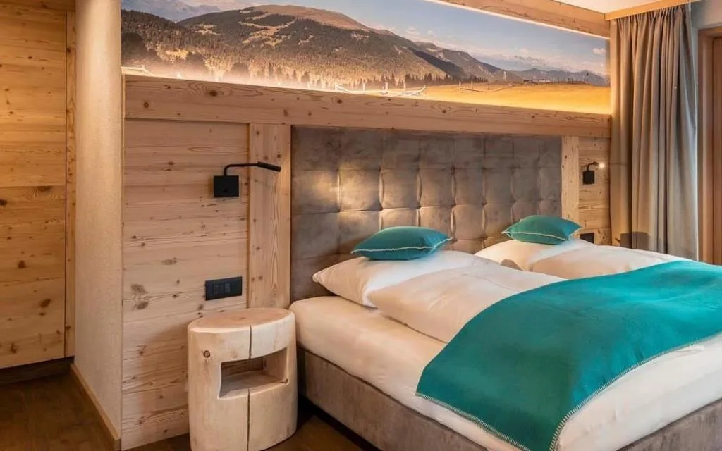 Camera da letto con letto matrimoniale, cuscini turchesi e pareti rivestite in legno