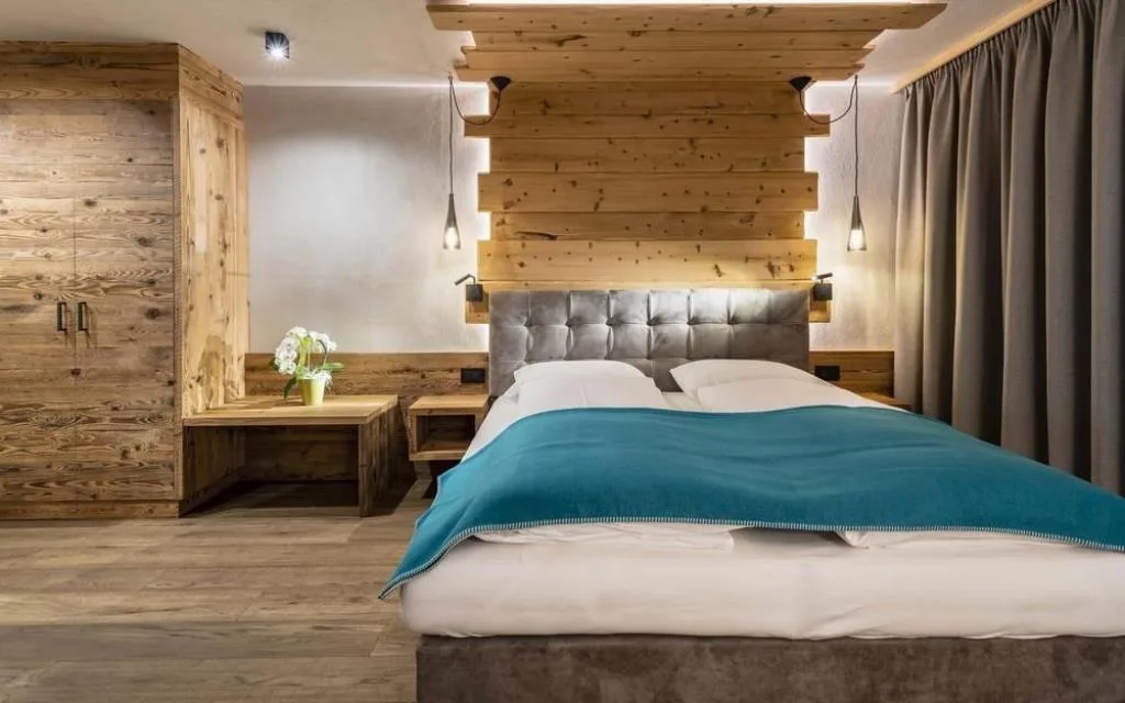 Camera da letto con testiera imbottita, illuminazione soffusa e armadio in legno