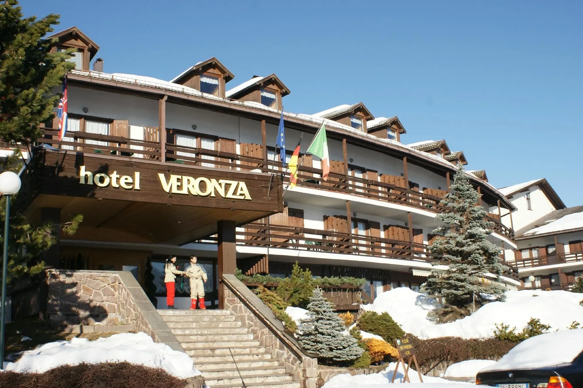 Ingresso dell'hotel Veronza con insegna, scala e neve invernale