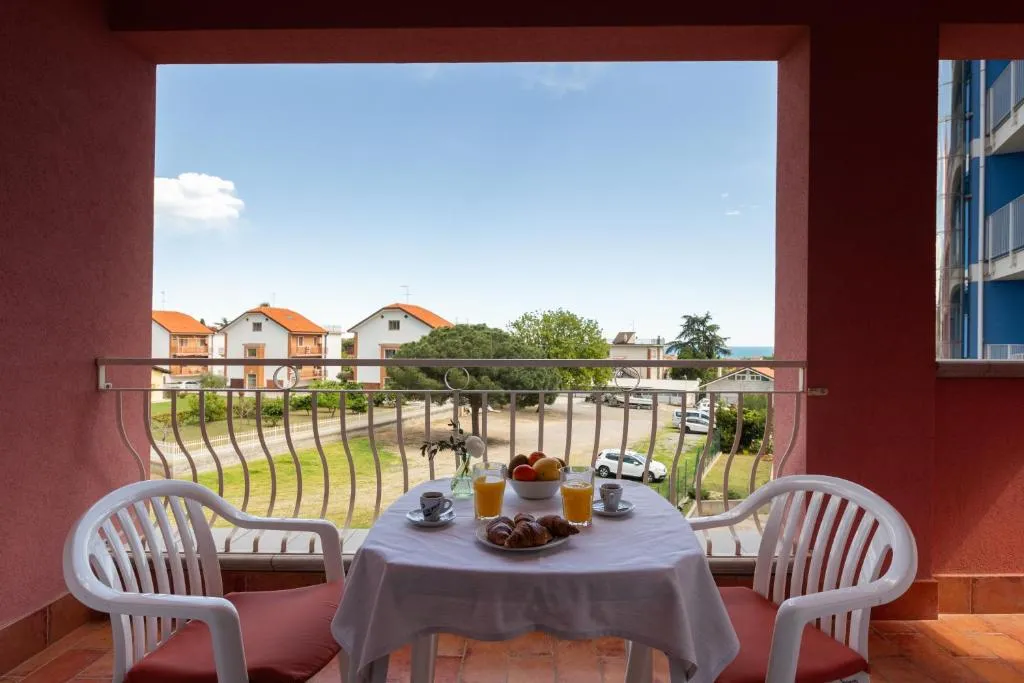 Balcone con tavolo apparecchiato per colazione e vista sulle case e sul mare