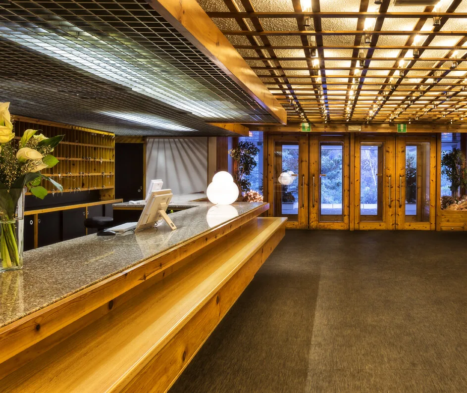 Reception dell'hotel con bancone in legno e soffitto decorativo luminoso
