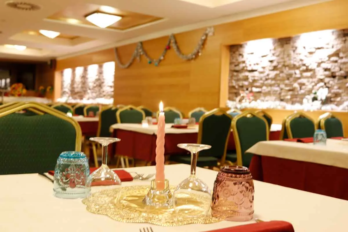 Tavolo del ristorante con candela e decorazioni natalizie