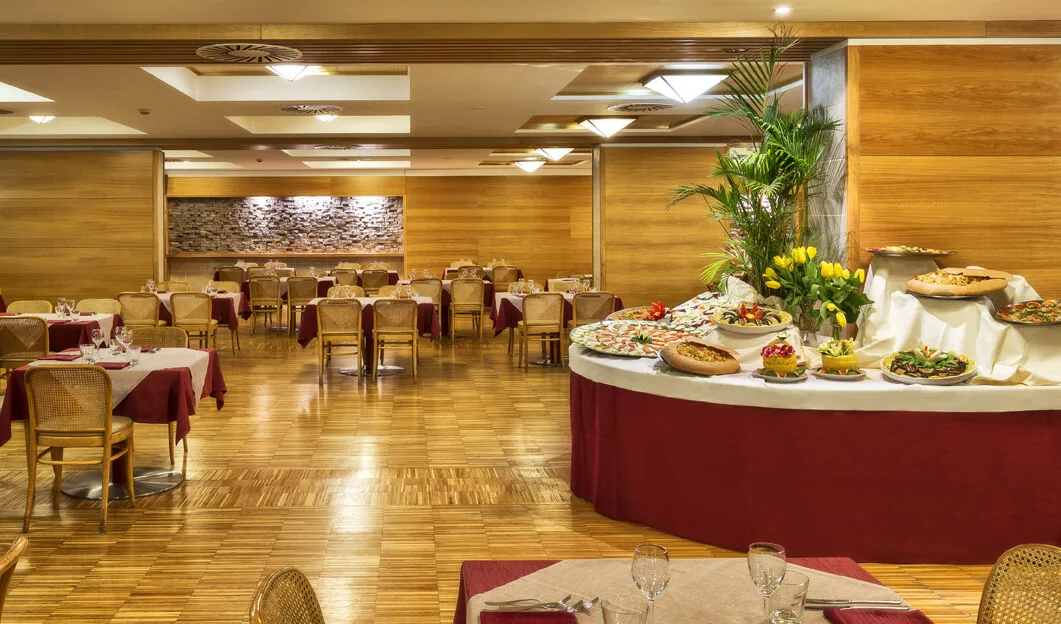 Sala ristorante con tavoli apparecchiati e buffet centrale di pietanze