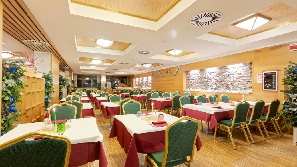 Sala da pranzo con tavoli apparecchiati e decorazioni natalizie