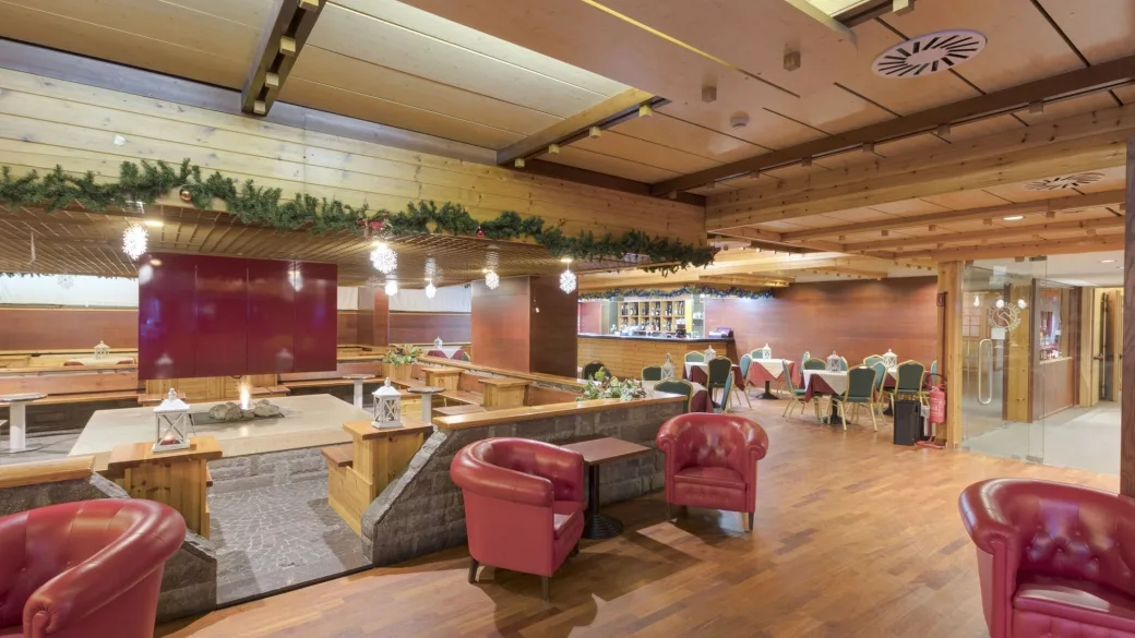 Zona bar e lounge con poltrone rosse e decorazioni natalizie