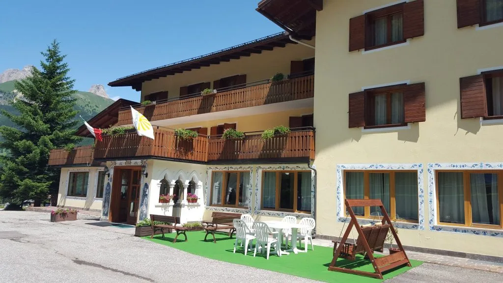 Terrazza esterna dell'hotel con tavolini, sedie e dondolo in estate