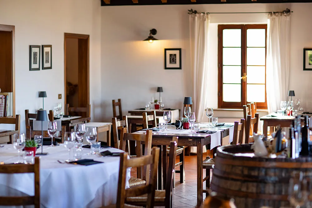 Sala da pranzo luminosa con tavoli apparecchiati e finestra con luce naturale