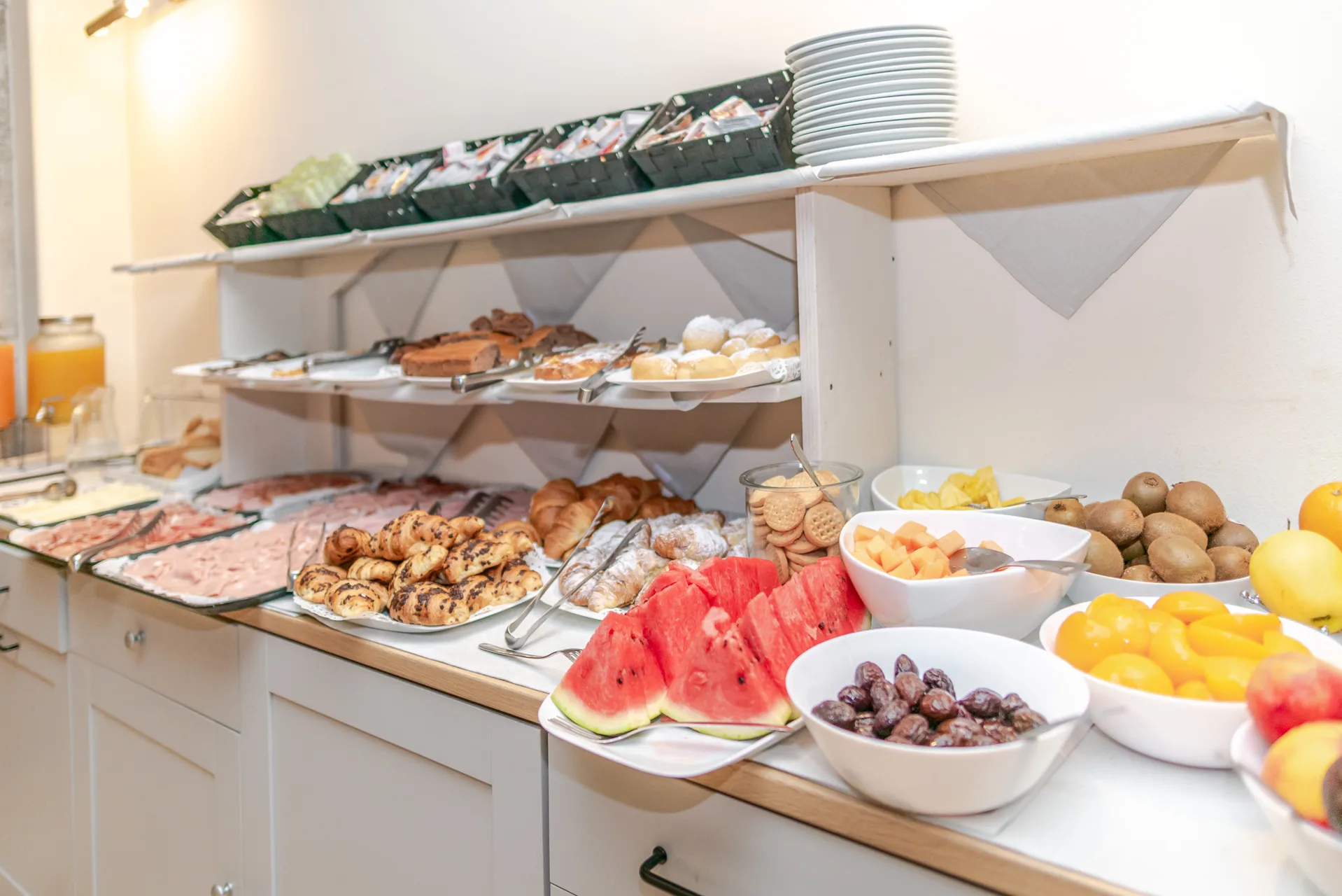 Buffet della colazione con affettati, dolci e frutta fresca