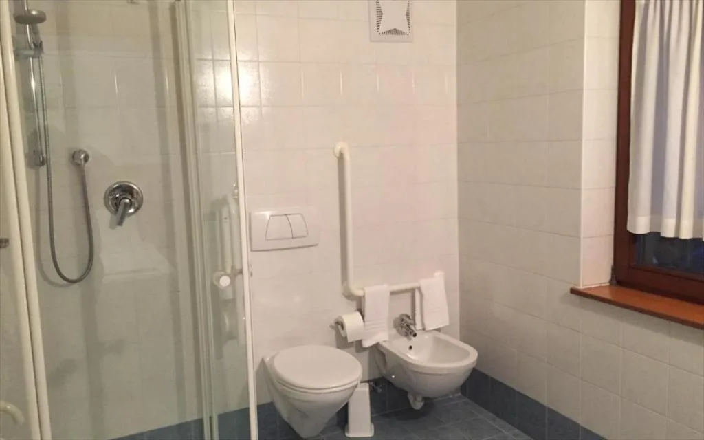 Bagno con doccia, WC, bidet e finestra, pavimento in piastrelle blu