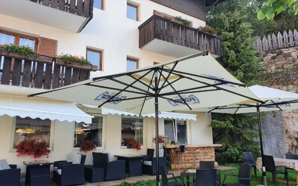 Terrazza esterna con ombrelloni, poltrone in rattan e fiori
