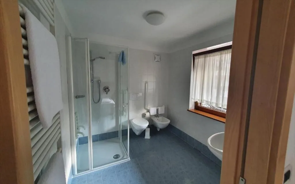 Bagno spazioso con doccia, WC, bidet, termoarredo e finestra