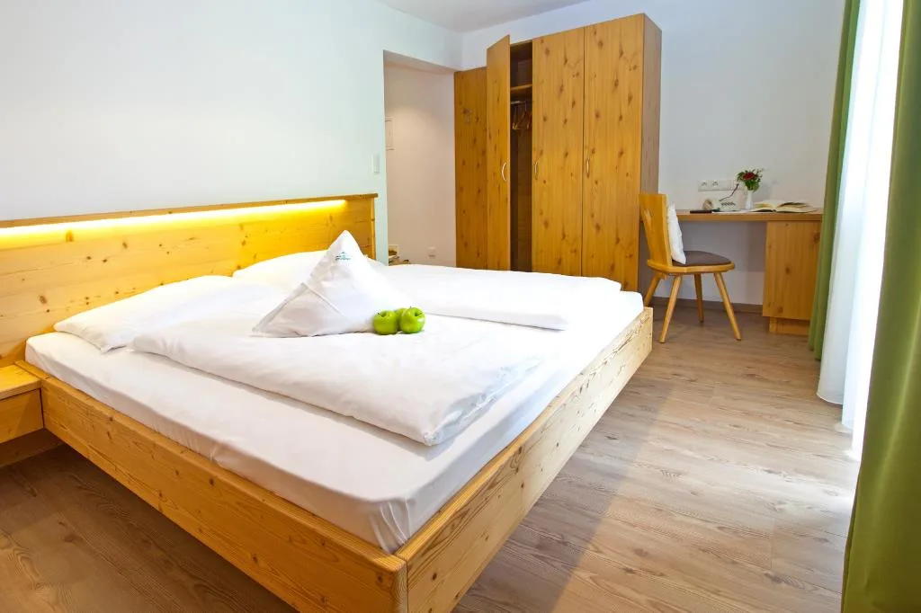 Camera da letto con letto matrimoniale in legno, armadio e scrivania
