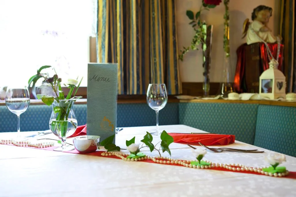 Tavolo del ristorante apparecchiato con menu, fiori e decorazioni eleganti