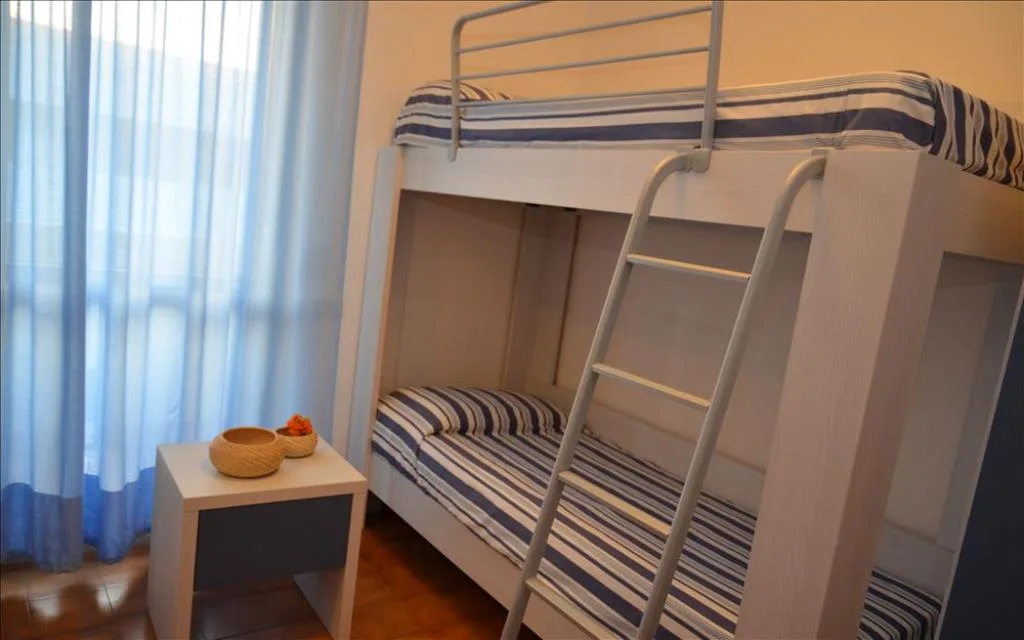 Cameretta con letto a castello a righe e tende azzurre