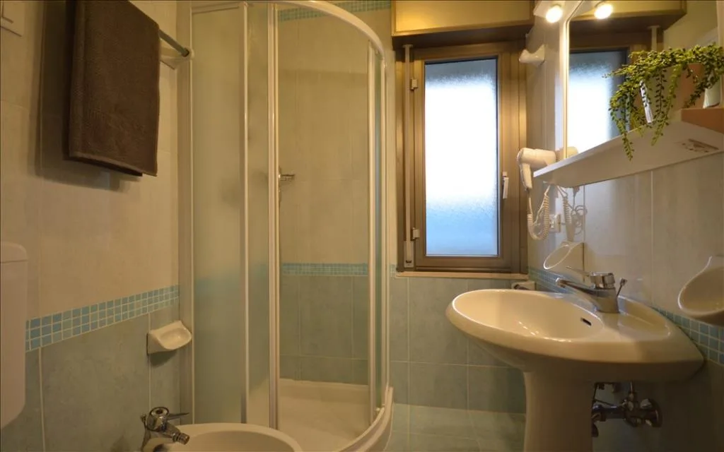 Bagno con doccia angolare, lavabo e bidet