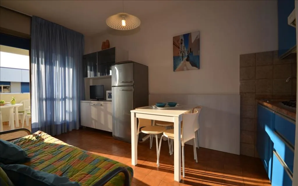 Monolocale con cucina, tavolo da pranzo e divano letto