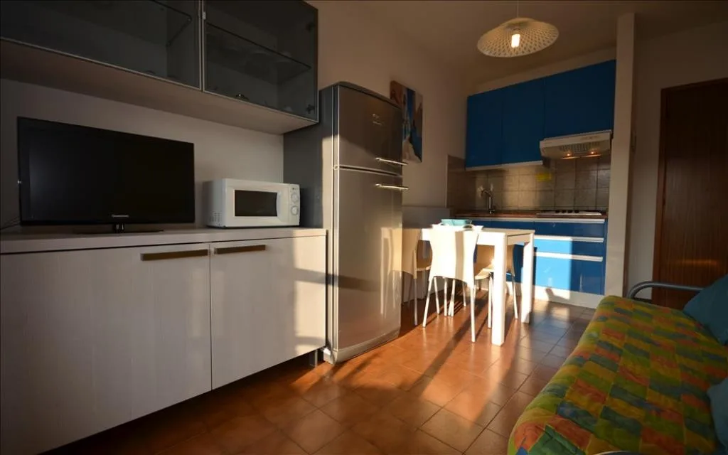 Angolo cottura con TV, microonde e cucina blu