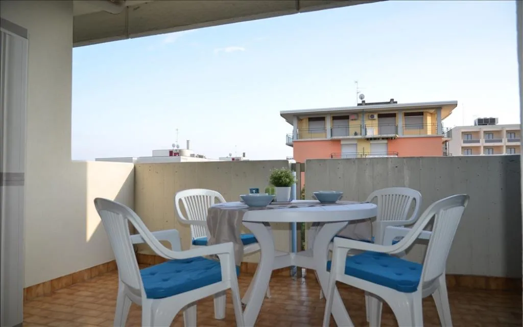 Balcone con tavolo rotondo, sedie e cuscini azzurri