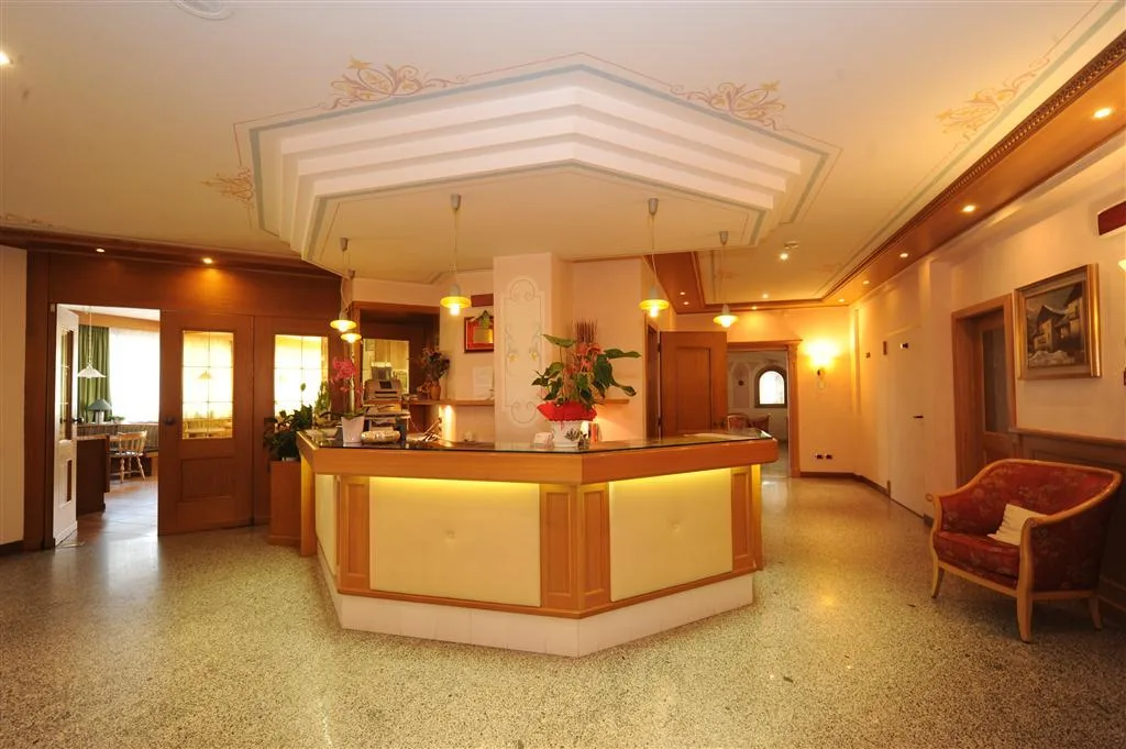 Reception dell'hotel con bancone in legno illuminato e decorazioni al soffitto