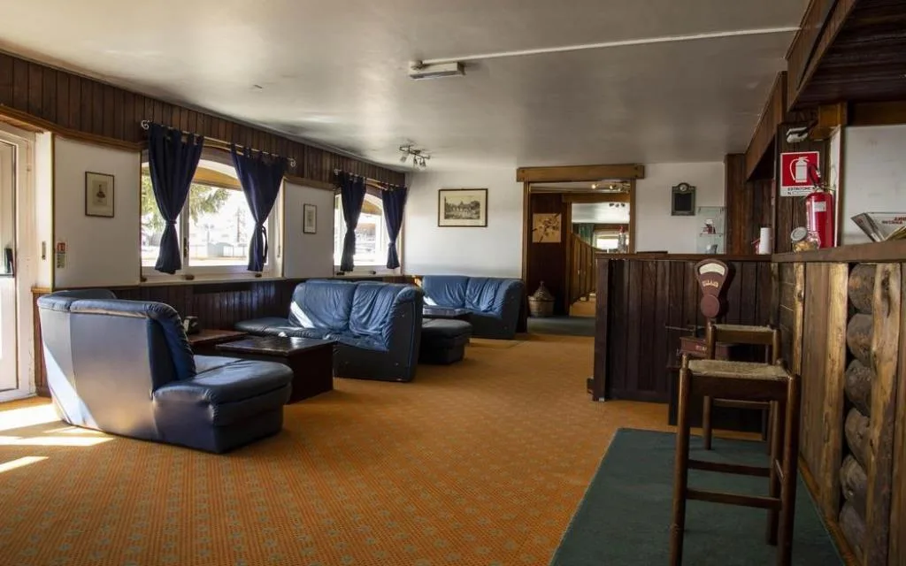 Sala lounge con divani in pelle blu e arredi in stile montano