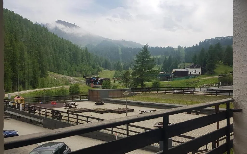 Vista estiva dal balcone sulle montagne, piste e area giochi