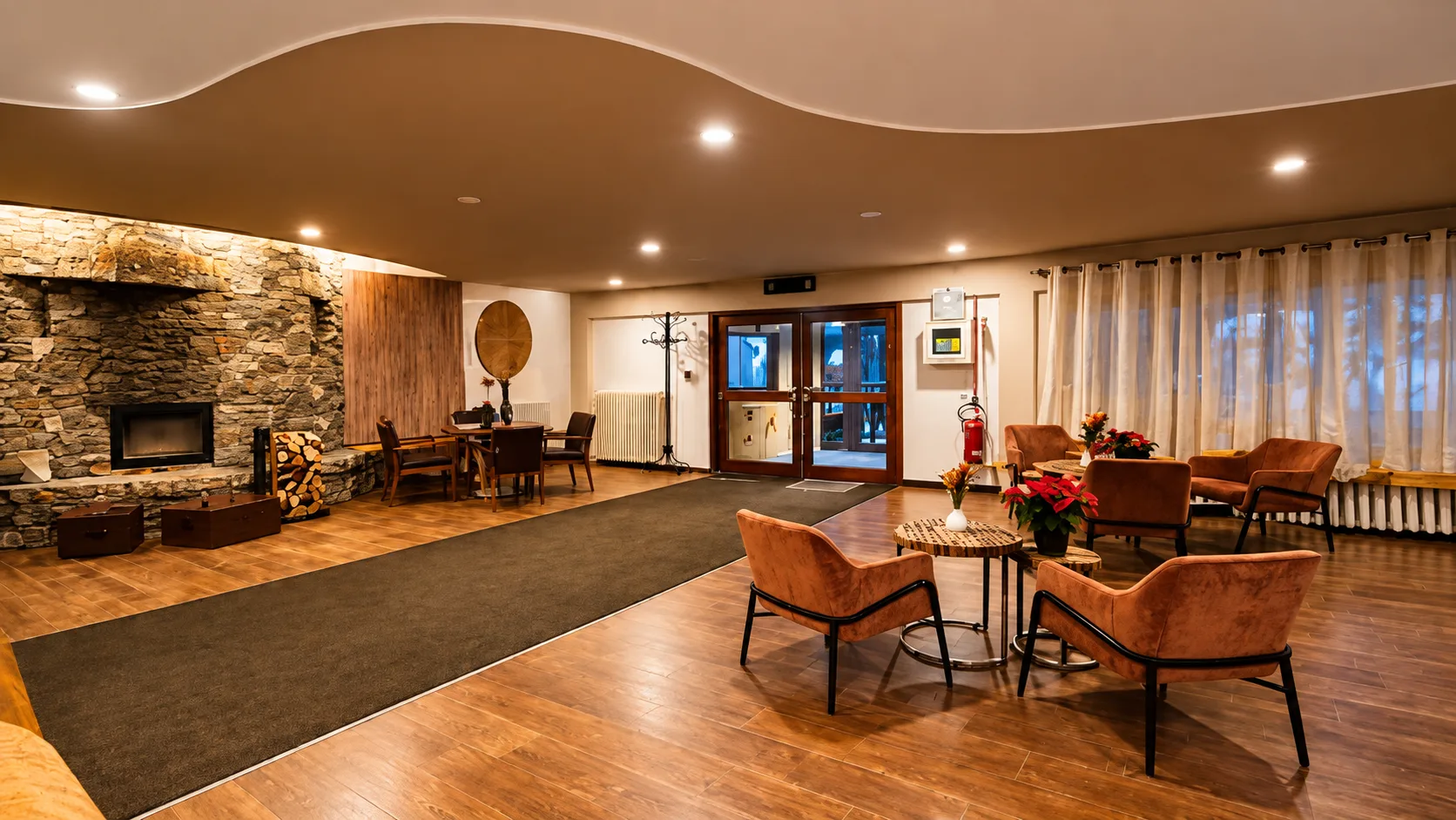 Hall dell'hotel con camino in pietra, poltrone in pelle e pavimento in legno