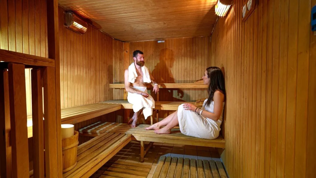 Coppia che si rilassa nella sauna in legno dell'area benessere dell'hotel