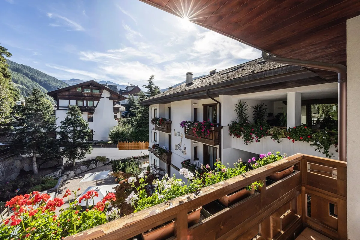 Balcone fiorito con vista sull'hotel e sulle montagne circostanti