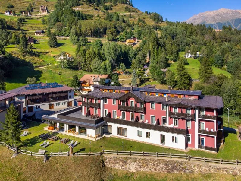 Vista aerea dell'hotel immerso nel verde con prati e boschi alpini in estate
