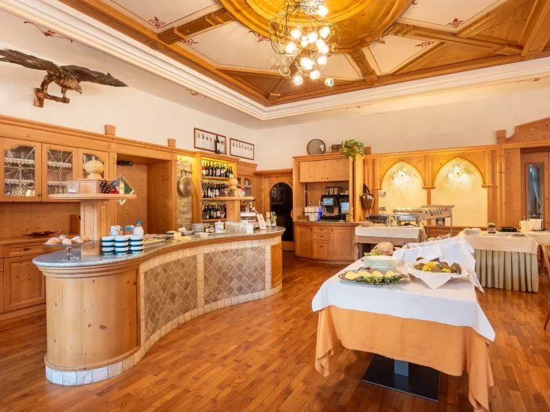 Sala colazione con buffet e arredi in legno con soffitto decorato