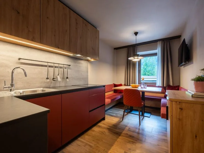 Angolo cottura di un appartamento con cucina rossa e zona pranzo