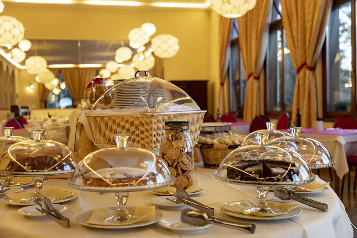 Buffet della colazione con dolci, torte e biscotti sotto campane di vetro