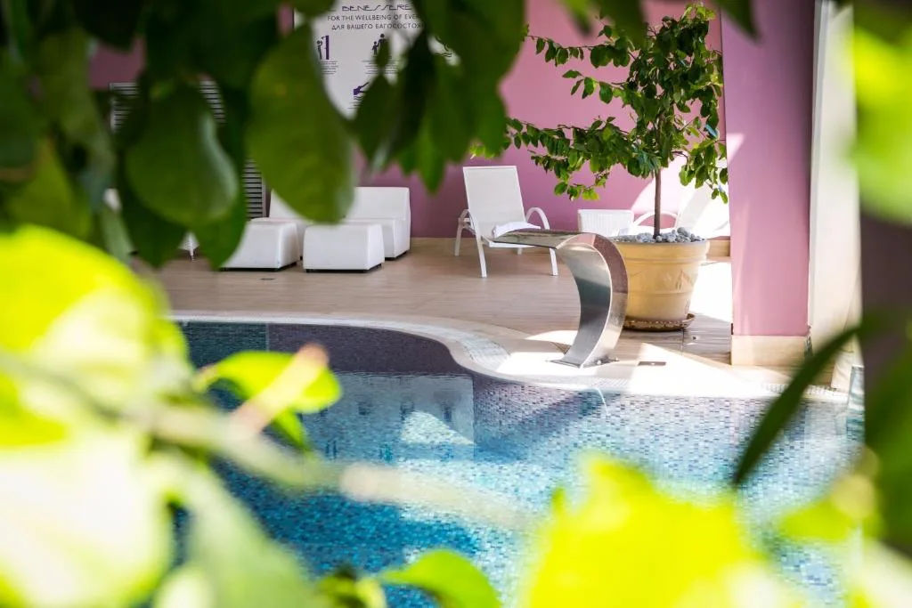 Dettaglio della zona relax della piscina con cascata e pareti rosa