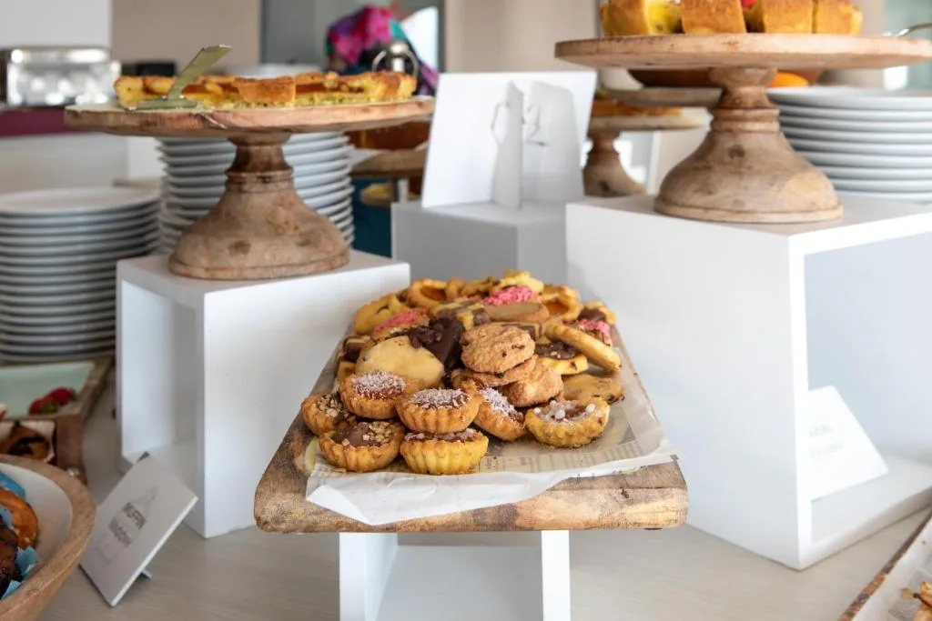 Buffet dolci con biscotti, crostatine e torte su alzate in legno
