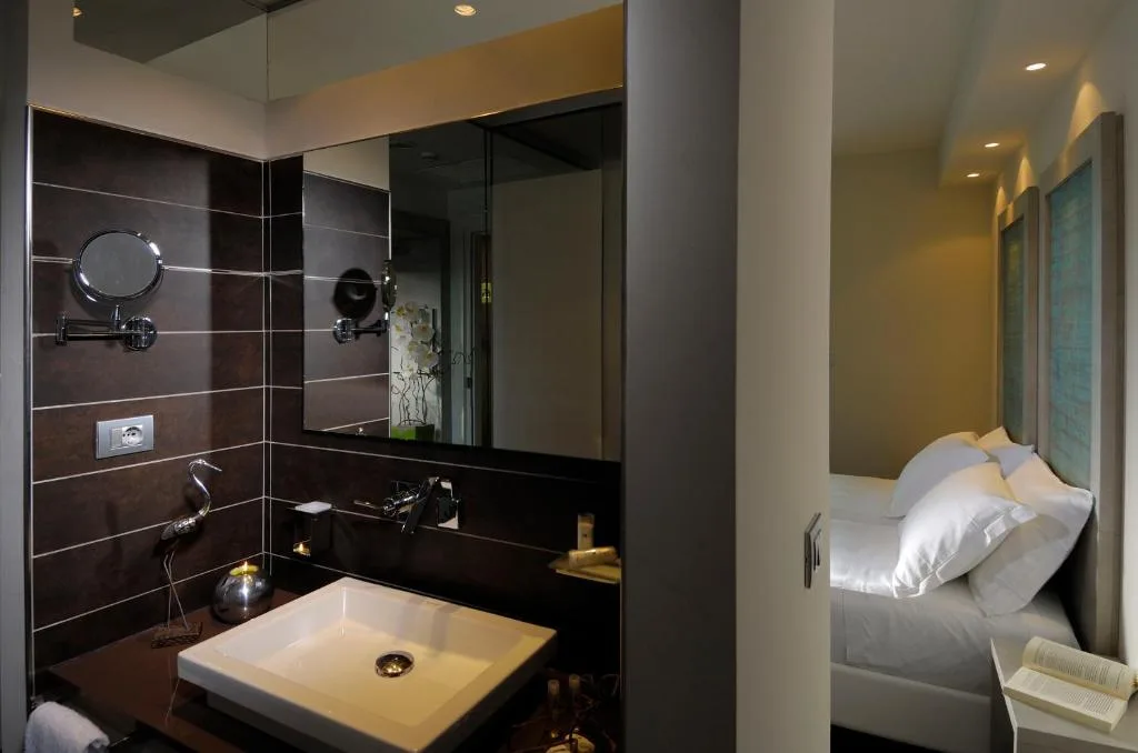 Bagno moderno con lavabo e specchio, adiacente alla camera da letto