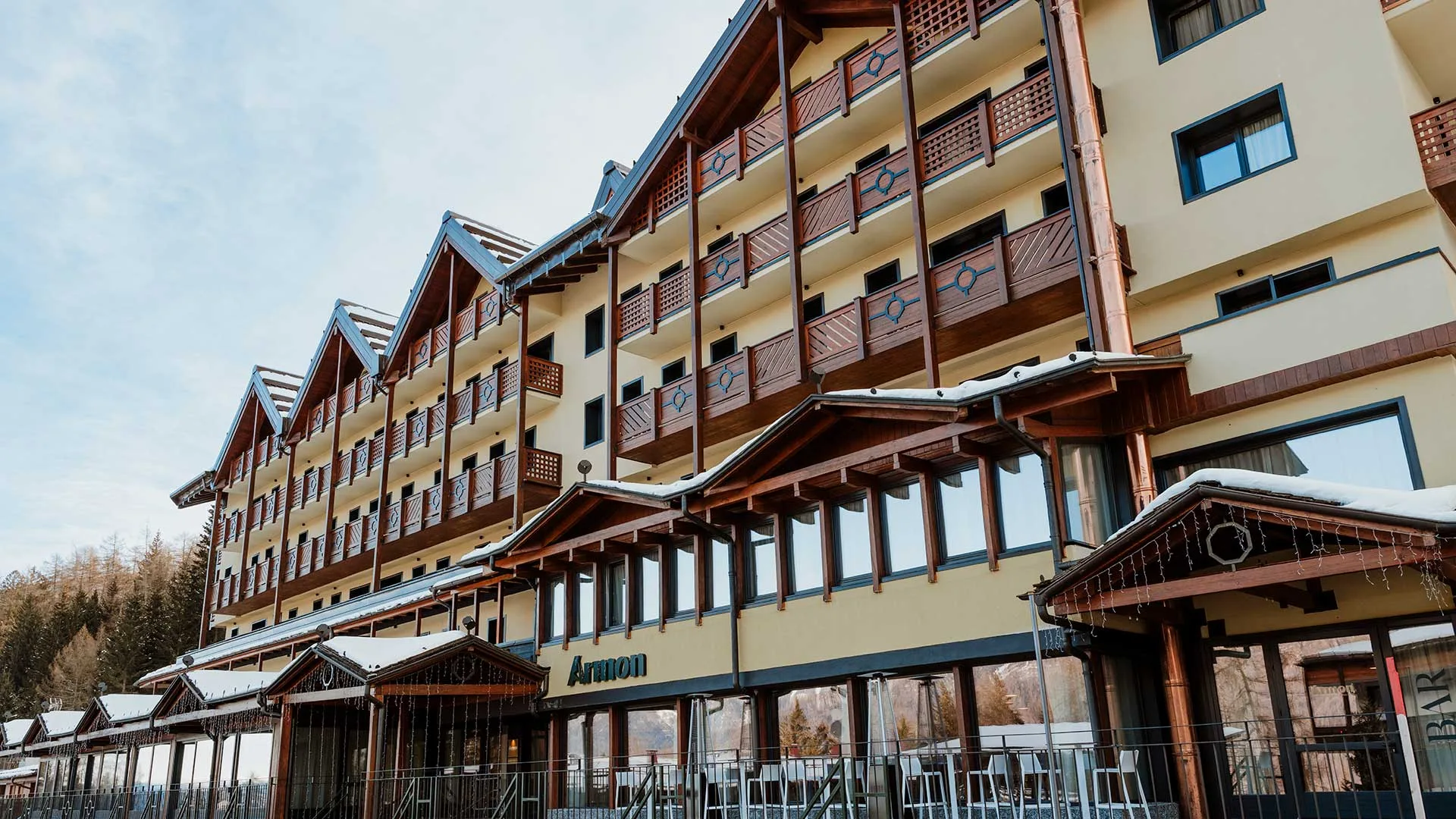 Facciata dell'Hotel Armon con balconi decorati e veranda vetrata