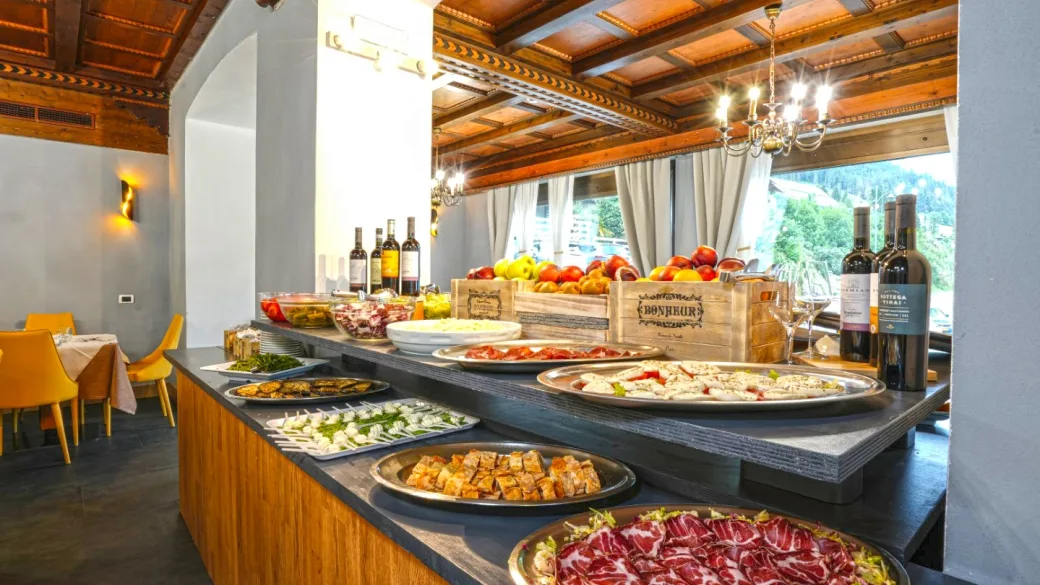 Ricco buffet con salumi, formaggi, verdure e vini in sala ristorante