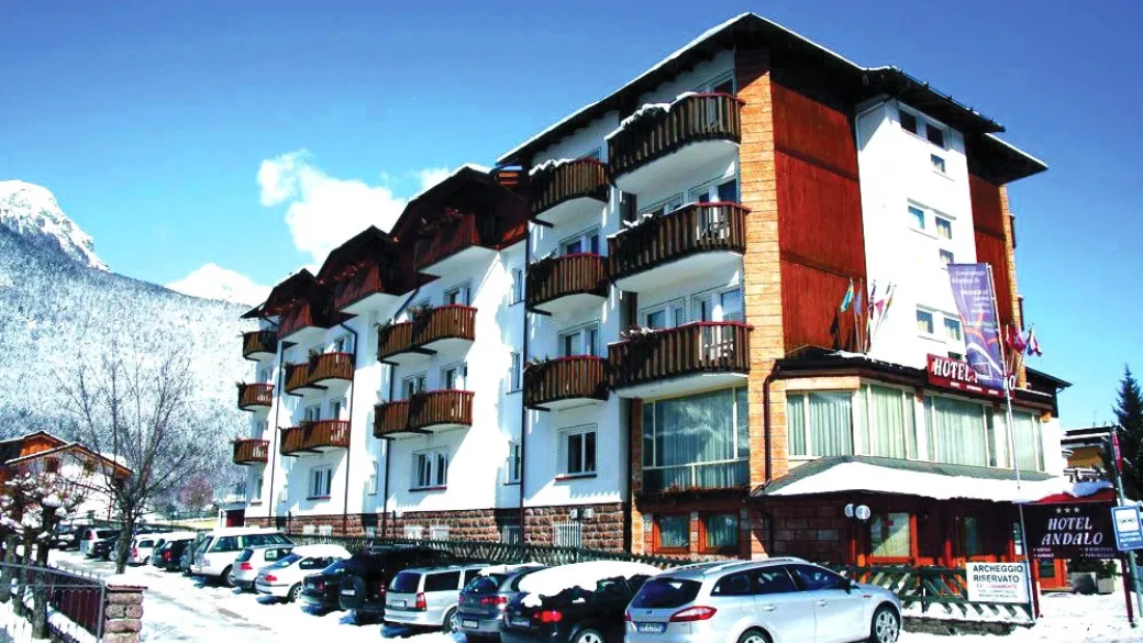 Esterno dell'Hotel Andalo con montagne innevate e parcheggio