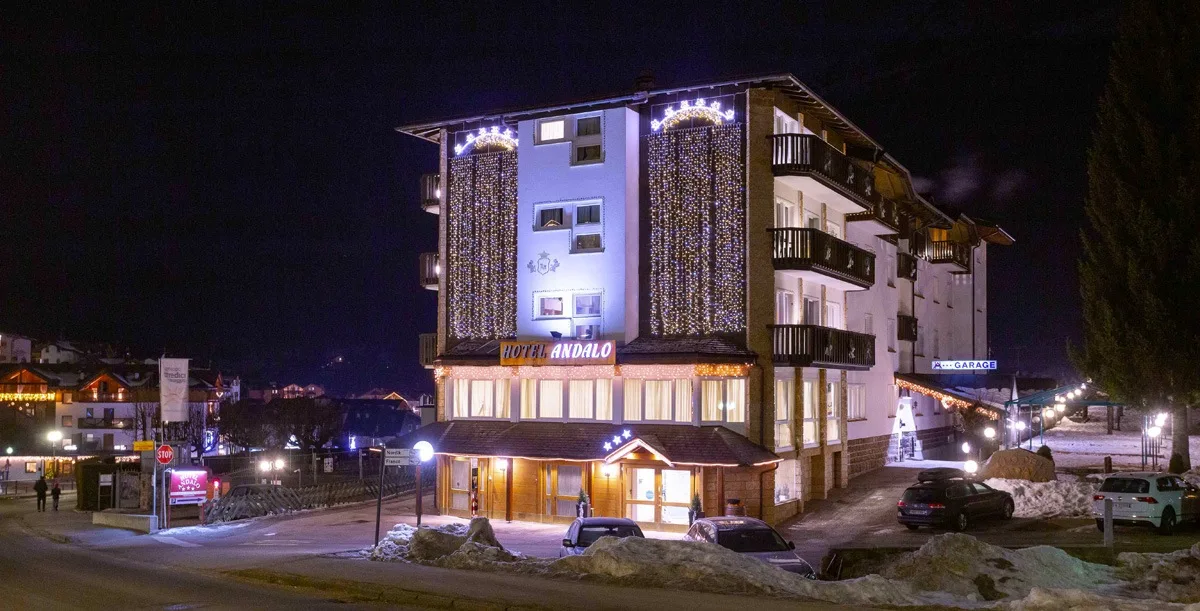 Facciata dell'Hotel Andalo illuminata di notte con luci natalizie