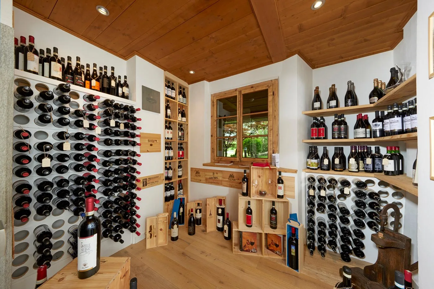 Cantina dei vini con bottiglie disposte su scaffali in legno