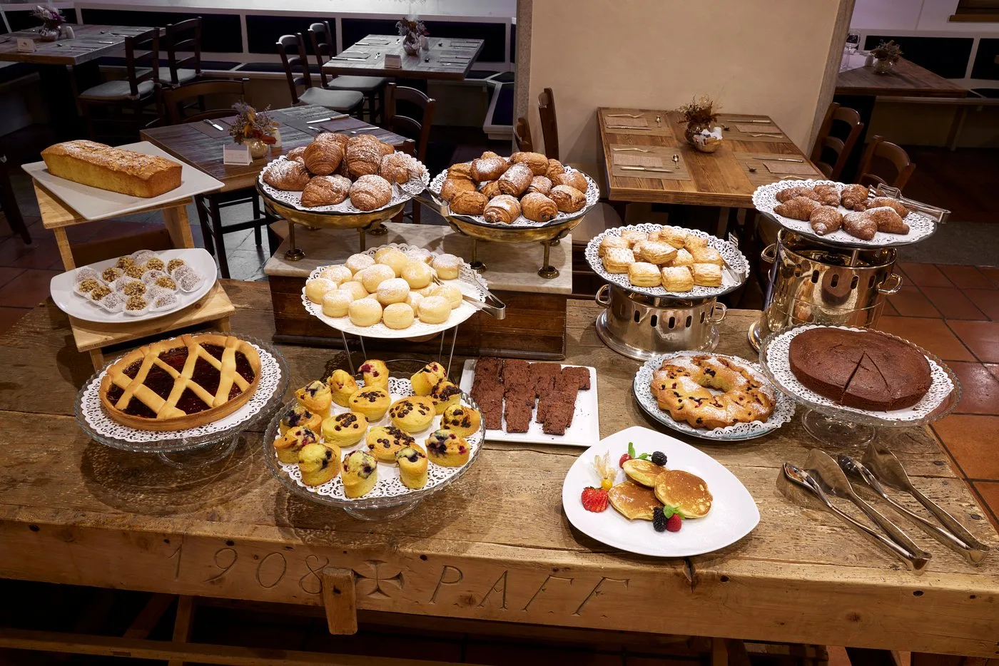 Buffet della colazione con torte, cornetti, muffin e dolci assortiti