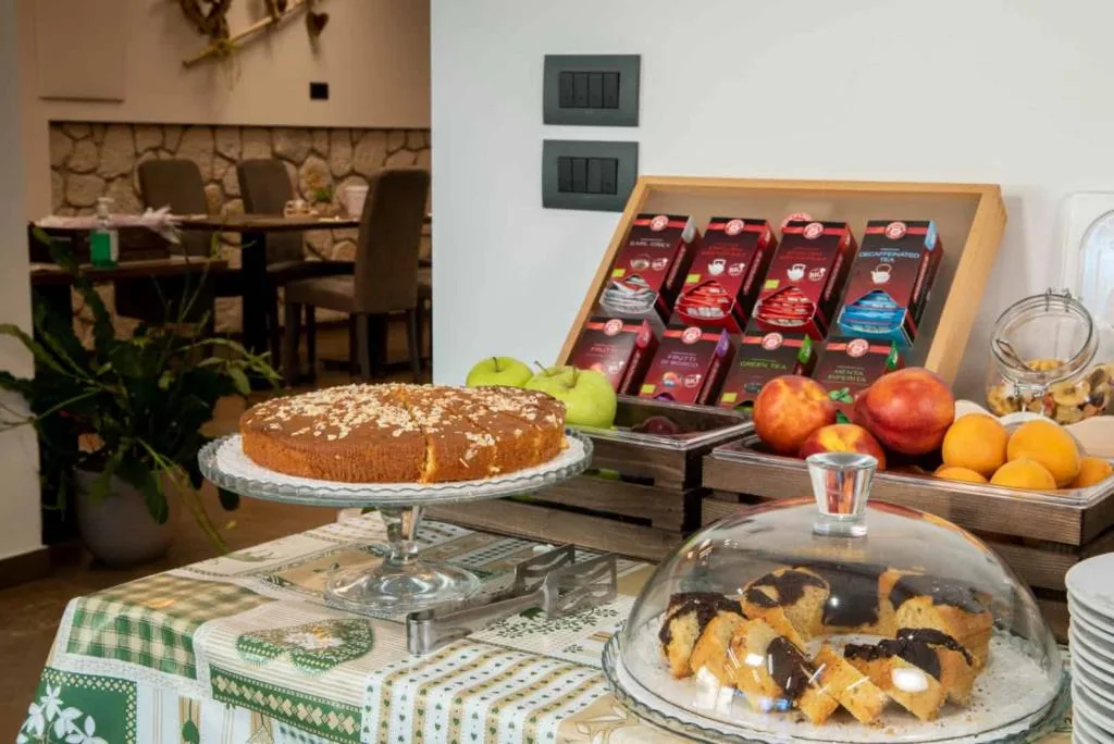 Buffet della colazione con torta, frutta fresca, tè e dolci