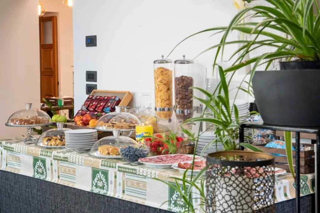 Buffet della colazione ricco con dolci, frutta, salumi e cereali